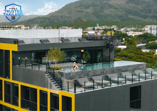 a woman in a swimming pool on top of a building at Blu Monkey Hub and Hotel Laguna, Bangtao Phuket in Bang Tao Beach
