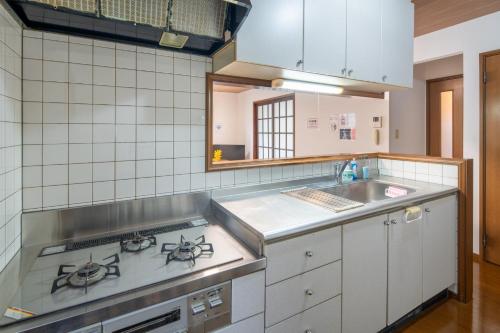 eine Küche mit Herd und Spüle in der Unterkunft SAKURA HOUSE - Vacation STAY 07254v in Hakone