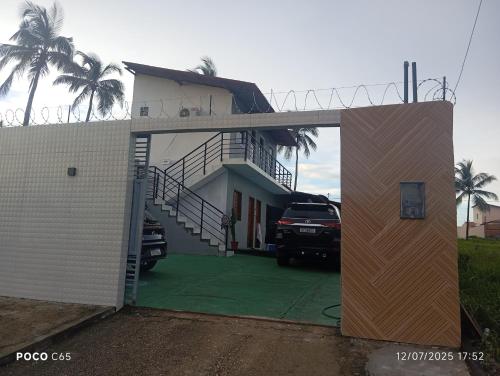 ein Haus mit einem davor geparkten Auto in der Unterkunft Hostel dos amigos in Salinópolis