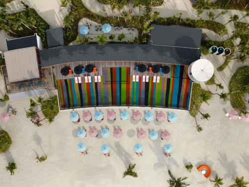 eine Draufsicht auf einen Strand mit Stühlen und Sonnenschirmen in der Unterkunft SO/ Maldives in Süd-Malé-Atoll