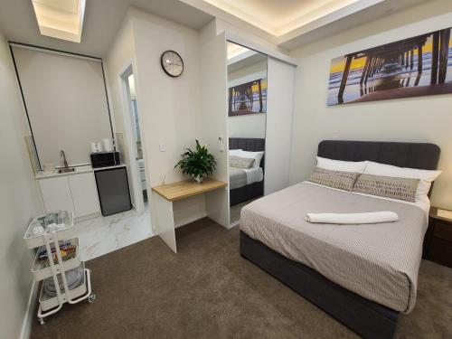 Un dormitorio con una cama y un reloj en la pared. en Harbour Retreat, en Hayborough