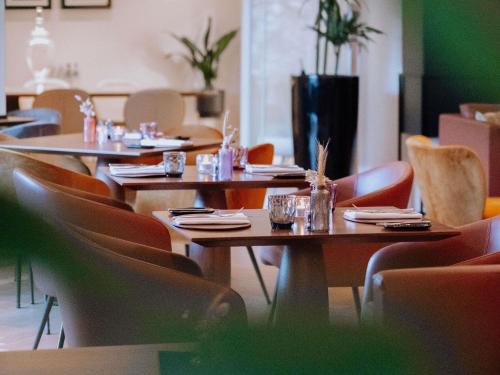 a group of tables and chairs in a restaurant at Le Louise Hotel Brussels - MGallery Collection in Brussels