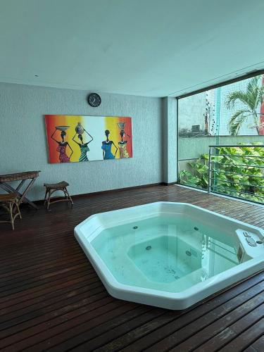a large bath tub in a room with a large window at Luxor Tambau 211 by Viva Hospedagens in Tambaú