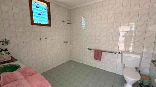 a bathroom with a toilet and a sink and a window at Love at Sellicks Chills in Sellicks Hill