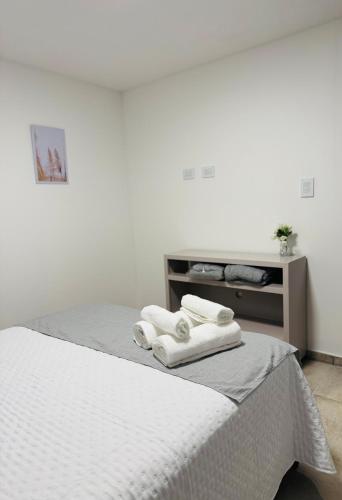 a bedroom with a bed with towels on it at AF-Homes-Villa María in Villa María