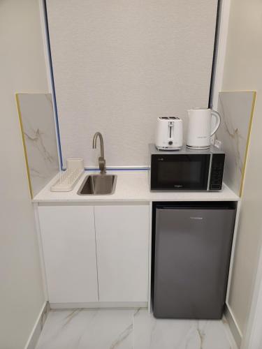 Una pequeña cocina con microondas y fregadero. en Harbour Retreat, en Hayborough