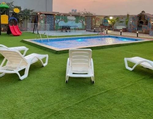 eine Gruppe von Liegestühlen vor einem Pool in der Unterkunft VIP Villa in Quai