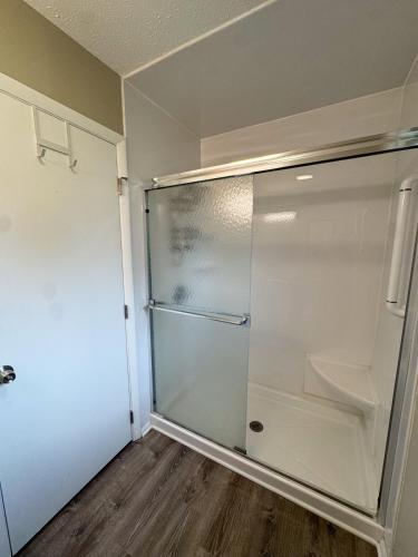 a glass refrigerator in a room with a wooden floor at 3BR Retreat near BrewDog, games, and lots of space in Groveport