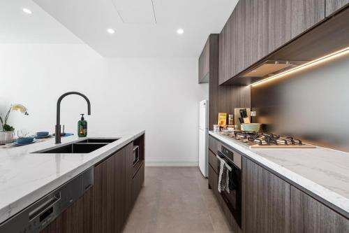 a kitchen with a sink and a counter top at SOP 08 Stylish and Cozy 2 Bedroom Apartment in Sydney