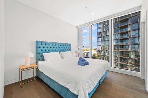 a bedroom with a large bed and a large window at SOP 08 Stylish and Cozy 2 Bedroom Apartment in Sydney