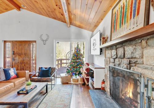 BlakesleeSki Chalet I EV Charger Sauna I Hot Tub I Movie Room & Firepit I PET Friendly的客厅设有壁炉和圣诞树