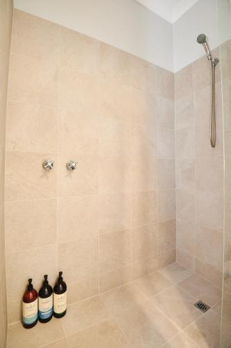 three bottles of wine sitting in a shower at Luxury Perth Apartment near Optus in Perth