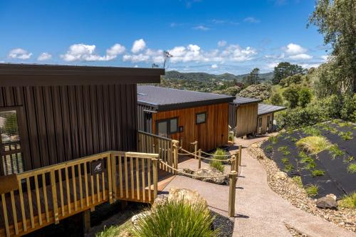 eine Reihe von Holzhütten in einem Resort in der Unterkunft Hidden Valley Waiheke in Palm Beach