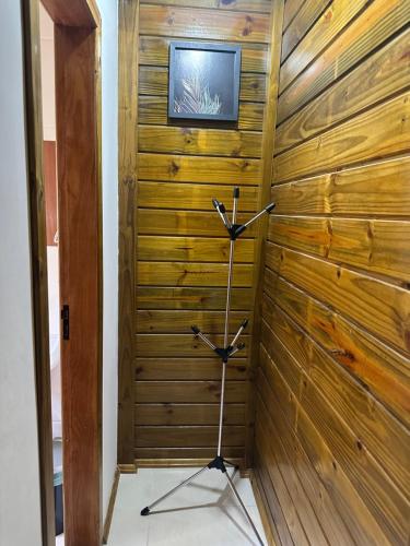 a room with a wooden wall with a tv on it at Pousada Hostels Foryou in Ibiraçu