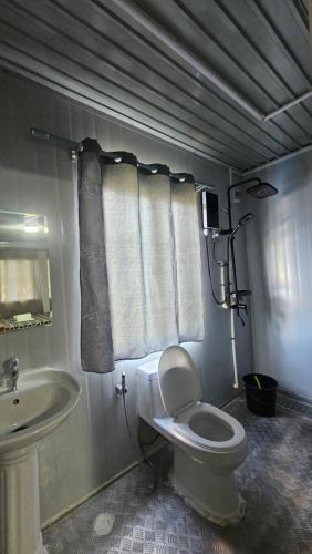 een badkamer met een wit toilet en een wastafel bij Rooms in Apo-estin in Cangatuyom