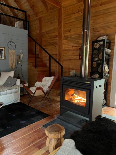 ein Wohnzimmer mit Kamin in einer Blockhütte in der Unterkunft Cabaña sobre el Lago Cholila in Cholila