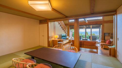 a dining room with a table and chairs and a living room at Hamachidorinoyu Kaisyu in Shirahama