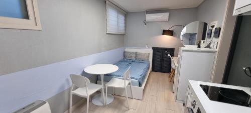 a small room with a bed and a table and chairs at Bombay Residence SNU Nakseongdae Station in Seoul