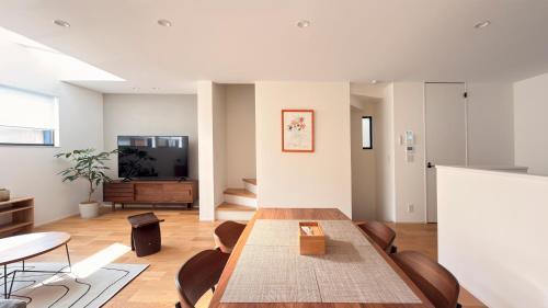 a dining room with a table and chairs at USJ 梅田 大阪城へ直通 駐車場付きモダン一軒家 JR弁天町駅3分 LIRI Aoi in Osaka