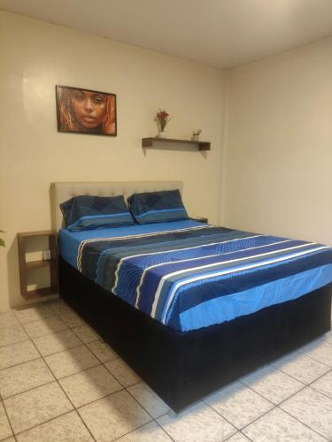 una camera da letto con un letto grande con lenzuola blu di Quarto aconchegante Completo a Rio Branco