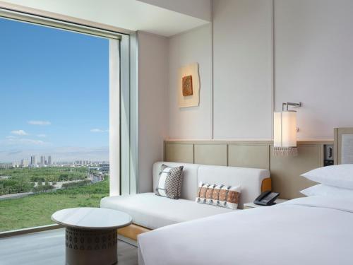 Courtyard by Marriott Korla في كورلا: غرفة معيشة مع أريكة ونافذة كبيرة