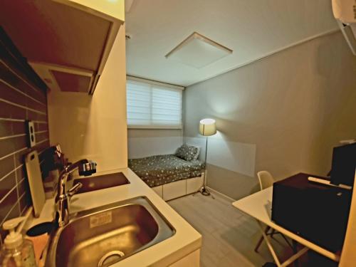 a bathroom with a sink and a bed in a room at Bombay Residence SNU Nakseongdae Station in Seoul
