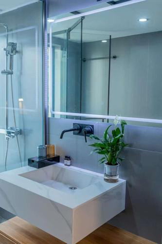 a bathroom with a sink and a large mirror at Shan Tao Inn -山韬客栈- Good location-English reception-Ticket service-Tourism planing-coffee-Laundry-kung fu Tea-Drone gopro rental in Zhangjiajie