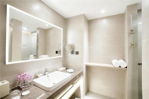a white bathroom with a sink and a mirror at Atour Hotel Guangzhou Yueqiao Branch in Guangzhou