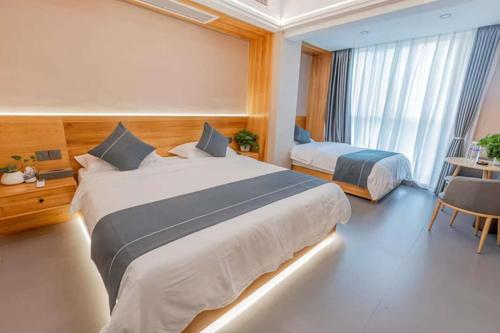 a hotel room with two beds and a table and a desk at Shan Tao Inn -山韬客栈- Good location-English reception-Ticket service-Tourism planing-coffee-Laundry-kung fu Tea-Drone gopro rental in Zhangjiajie