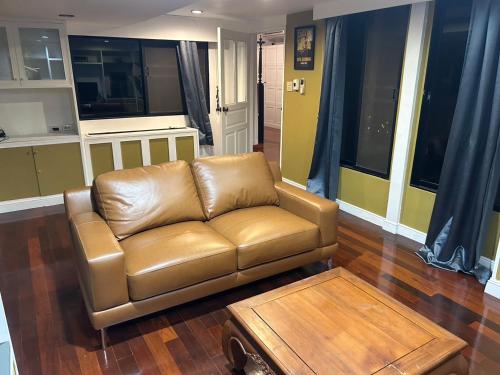 a brown leather couch in a living room at Family room in Bang Kapi