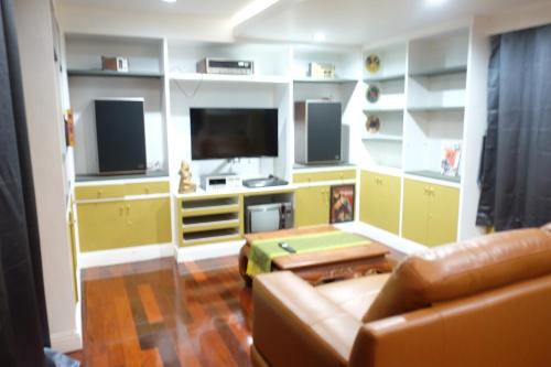a living room with a couch and a flat screen tv at Family room in Bang Kapi