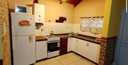 Una cocina con un refrigerador blanco y una estufa. en Quintacolastinenorte, en Santa Fe