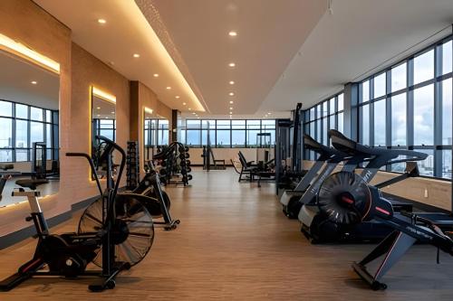 - une salle de sport avec des équipements de cardio-training dans un bâtiment doté de fenêtres dans l'établissement Flat Luxo 35º Andar • Vista Incrível da Cidade, à Goiânia