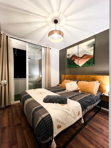 Apartamento con vista a Lago y dos Volcanes في فيلاريكا: غرفة نوم بسرير كبير ونافذة كبيرة