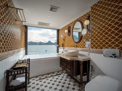 a bathroom with a sink and a tub and a window at Lamour Cruise in Ha Long