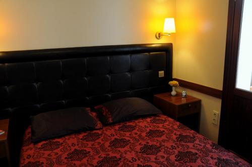 a bedroom with a large bed with a red bedspread at Butik Pendik Hotel in Istanbul