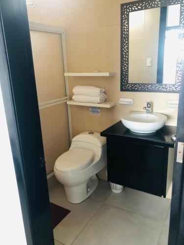 a bathroom with a toilet and a sink at Habitaciones privadas in Puerto Villamil