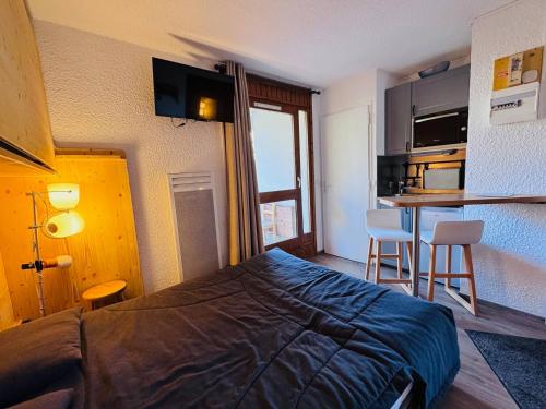 a hotel room with a bed and a kitchen at Studette cosy pour 2 aux Deux Alpes avec balcon - FR-1-546-62 in Les Deux Alpes