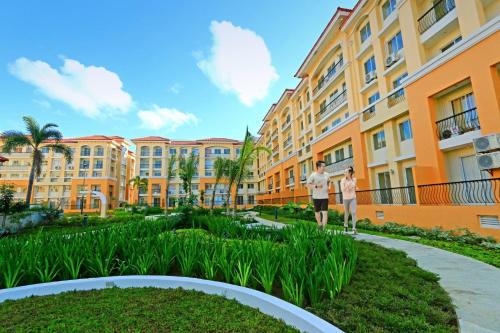 two people standing in front of a building at San Remo Oasis at City Di Mare in Cebu City