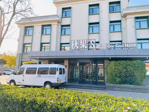 北京秋果s酒店的一辆白色厢式货车停在一栋建筑物前。