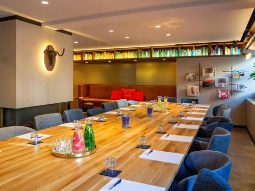 INK Hotel Amsterdam - MGallery Collection في أمستردام: غرفة مؤتمرات كبيرة مع طاولة طويلة وكراسي