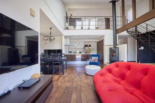 a living room with a red couch and a dining room at The Deer Valley Yamanakako in Yamanakako