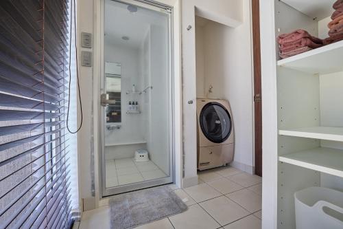 a bathroom with a washing machine and a walk in shower at The Deer Valley Yamanakako in Yamanakako