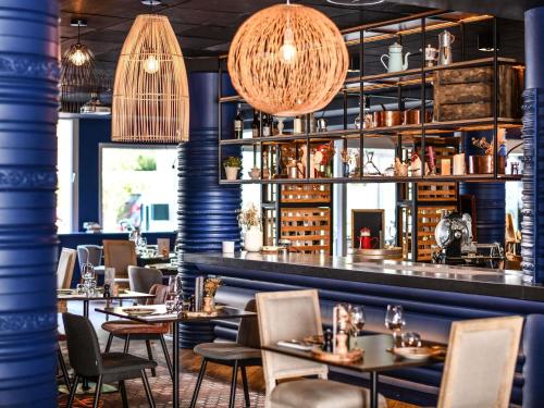 un ristorante con tavoli e sedie e un bar di Hotel Mercure Château de Fontainebleau a Fontainebleau