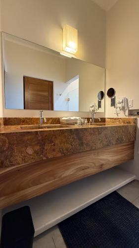 a bathroom with two sinks and a large mirror at Azul Beach Kite Resort in El Sargento