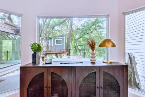 加兰Garland 33 mile to Fifa Stadium Texas-Size Unique Home with Treehouse Suite by Vacation Your Way的带木柜和大窗户的客厅