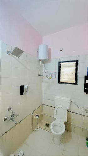 ein Badezimmer mit Toilette und Fenster in der Unterkunft Silver ok appartment in Shirdi