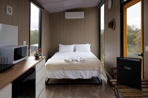 una habitación de hotel con una cama y un televisor en The Bunjil by Tiny Away, en Steels Creek