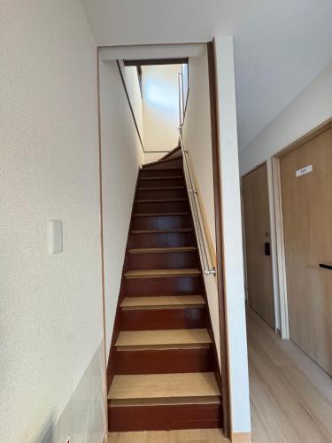 a staircase in a house with wooden floors at Ippaku 一泊 in Izumi-Sano