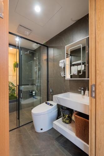 a bathroom with a toilet and a shower and a sink at Khách sạn Phố cổ Hotel Ninh Bình in Ninh Binh